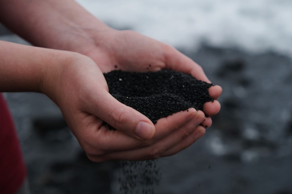 person-holding-black-soil-lymzdag-zgq